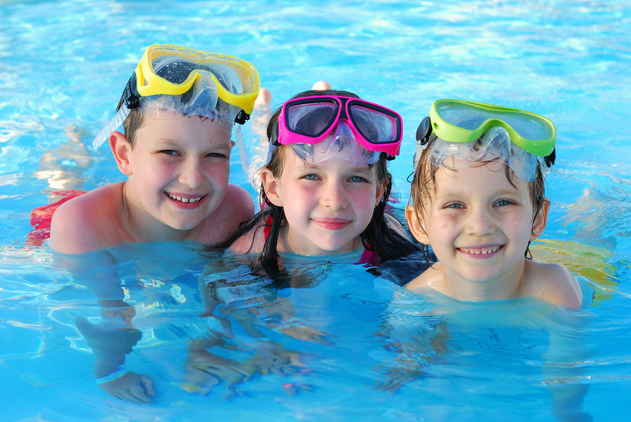 Happy kids playing and having fun together in the pool