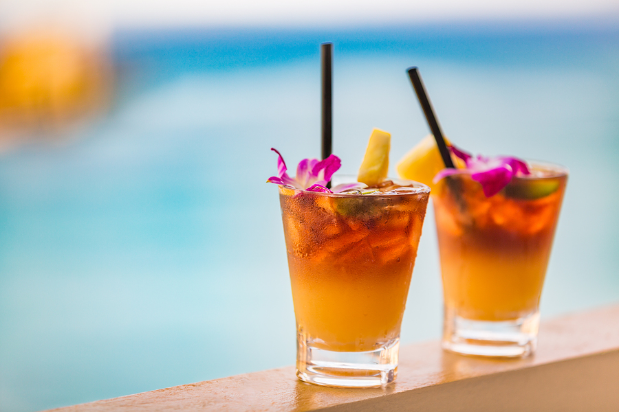mai tai drinks on waikiki beach swimming pool bar travel vacation in Honolulu, Hawaii. Alcohol cocktails with ocean view, luau party nightlife at club.