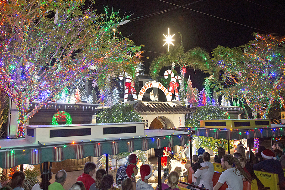 Conch Train Holiday Lights Tour revelers enjoy the prize-winning “North Pole” spectacle at 503 Washington Street Friday night. The tours, which concluded on Friday, are among many island-wide Key West Holiday Fest events that kicked off in November and continue through December 31 with an array of festive choices for ringing in the New Year. For more information on Holiday Fest happenings, contact the Lodging Association at 305-296-4959 or visit keywestholidayfest.com. (Photo Carol Tedesco/KeyWestHolidayFest.com)